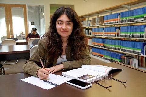 Student taking notes in library