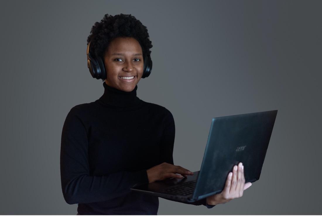 A woman holding up a laptop computer